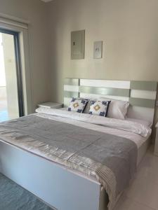 Un dormitorio con una cama grande con almohadas. en Home X4, en Al Wāşil