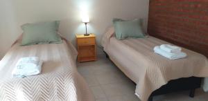 Dos camas en una habitación con toallas. en CALAFATE CENTER APARTS en El Calafate
