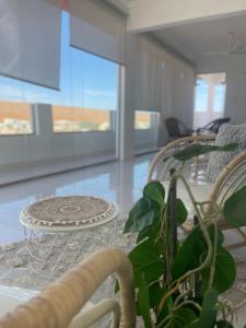 uma sala de jantar com uma mesa de vidro e uma planta em Home X4 em Al Wāşil