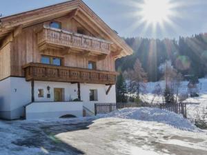 Casa con balcón de madera sobre la nieve en Kometer App Almrose, en Fendels