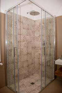 a shower with a glass enclosure in a bathroom at Pavì Trulli e Suites in Locorotondo