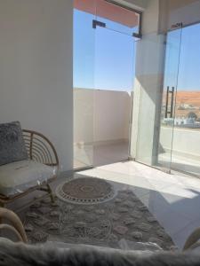 sala de estar con silla y ventana en Home X4, en Al Wāşil