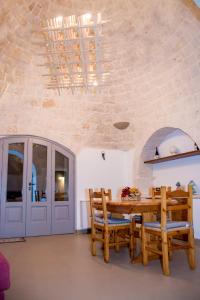 a dining room with a wooden table and chairs at Pavì Trulli e Suites in Locorotondo