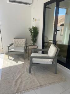 a living room with two chairs and a table at Home X4 in Al Wāşil