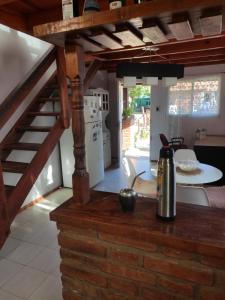 cocina y sala de estar con escalera y mesa en Cabañas Céntricas Don Simon en Merlo