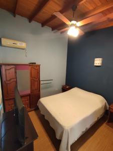 een slaapkamer met een bed en een flatscreen-tv bij Cabañas Céntricas Don Simon in Merlo