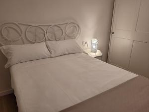 a bedroom with a white bed with a metal headboard at Apartamento Ejido Centro in El Ejido