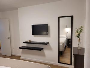 a room with a mirror and a bed and a television at Apartamento Ejido Centro in El Ejido