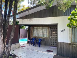 dom z 2 niebieskimi krzesłami na patio w obiekcie Casa do Sussego w Foz do Iguaçu