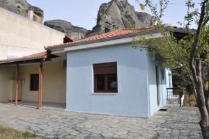 a white house with a mountain in the background at Ananta House in Kalabaka