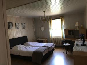 una camera con letto, tavolo e finestra di Beau-sejour a Francorchamps