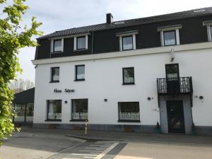 a white building with a black roof at Beau-sejour in Francorchamps