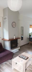 a living room with a couch and a table and a clock at Villa Eva I in Nédhousa