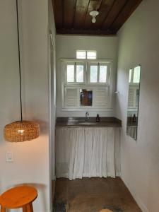 a kitchen with a sink and a window at Pousada Cantoria in Cumuruxatiba