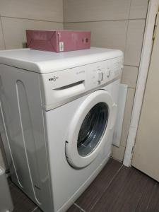 una lavadora con una caja rosa encima en Linda's house 2, en Agria
