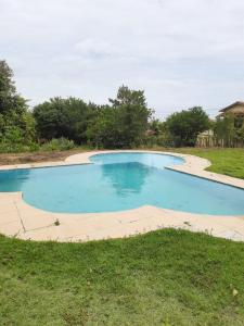 an empty swimming pool in a grassy field at Pousada Cantoria in Cumuruxatiba