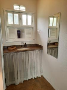 uma casa de banho com um lavatório e um espelho em Pousada Cantoria em Cumuruxatiba