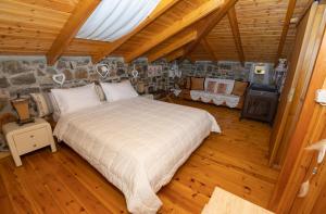 ein Schlafzimmer mit einem großen Bett und einer Steinmauer in der Unterkunft Villa Galateia in Dhafnés