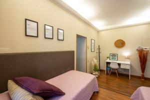 a bedroom with a bed and a desk in it at Colosseo Ohana Suite in Rome
