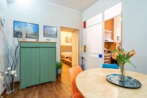 a dining room with a green cabinet and a table at Colosseo Ohana Suite in Rome