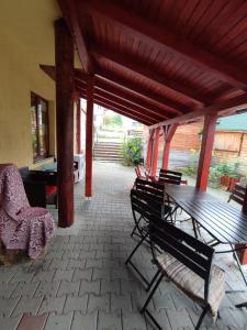un patio con una mesa de madera y sillas. en Edelweis Floare de Colt, en Borsec