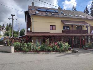 a house with some flowers in front of it at Edelweis Floare de Colt in Borsec