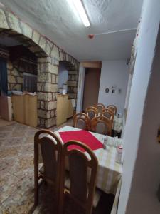 a dining room with a table and chairs and a stone fireplace at Edelweis Floare de Colt in Borsec