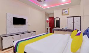 a bedroom with a large bed and a tv at Itsy By Treebo - Hill Town 500 Mtrs From Madikeri Fort in Madikeri