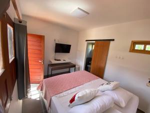 a bedroom with a bed and a desk and a television at Pousada Suzimar in Fernando de Noronha