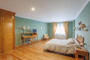 1 dormitorio con cama, escritorio y mesa en Pensión Casa Pachín, en Taragoña