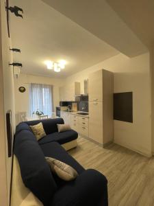 sala de estar con sofá azul y cocina en Gardone Apartment - ampio Appartamento con 2 camere da letto - Comodo per Duomo! en Milán