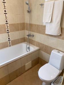 a bathroom with a toilet and a tub and a sink at HQ Apartment Flora Violet in Borovets +7 photos