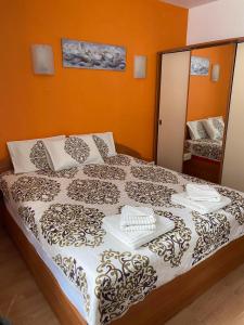 a bedroom with a large bed with orange walls at HQ Apartment Flora Violet in Borovets