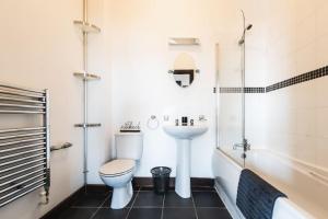 a bathroom with a toilet and a sink and a tub at Deluxe suite- 2 bed in Southampton Central in Southampton