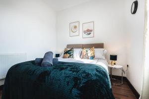 1 dormitorio con 1 cama grande con manta verde en Deluxe suite- 2 bed in Southampton Central, en Southampton