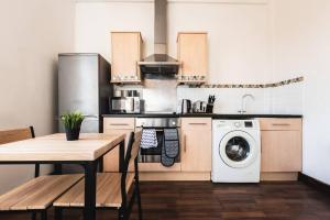 a kitchen with a table and a washing machine at Deluxe suite- 2 bed in Southampton Central in Southampton