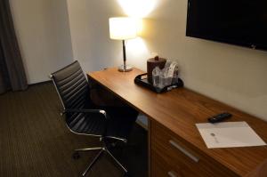 - un bureau avec une lampe et une chaise dans une chambre d'hôtel dans l'établissement Casa Inn Business Irapuato, à Irapuato