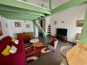 a living room with a red couch and a table at Appartement OTP2 de standing proche plage et lagon in La Saline les Bains