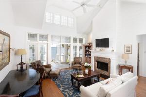 a living room with white furniture and a fireplace at The Cottages on Charleston Harbor in Charleston