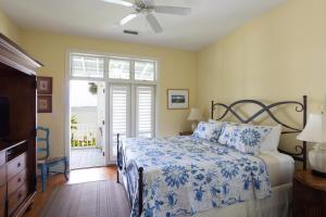 a bedroom with a bed with a blue and white comforter at The Cottages on Charleston Harbor in Charleston