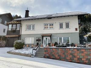 een huis met sneeuw op de grond ervoor bij Ferienwohnung Engelmann in Winterberg