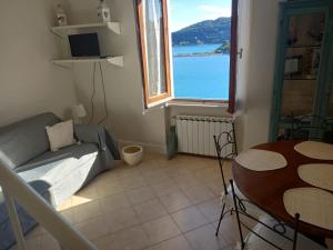 a living room with a couch and a table and a window at Vittoria 19 in Portovenere