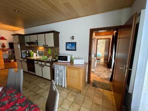 eine Küche mit einer Spüle und einer Theke mit einer Mikrowelle in der Unterkunft Ferienwohnung Engelmann in Winterberg