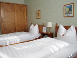 two beds in a hotel room with white pillows at Motel Hamburg in Hamburg