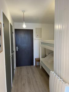 een slaapkamer met een blauwe deur en een stapelbed bij Appartement avec terrasse in Les Deux Alpes