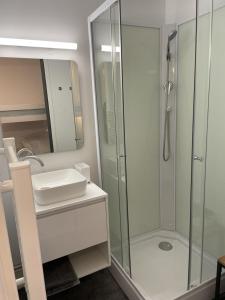 een badkamer met een glazen douche en een wastafel bij Appartement avec terrasse in Les Deux Alpes