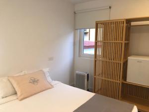 1 dormitorio con cama con almohada y ventana en Casa da Praça Square Suites, en Coímbra