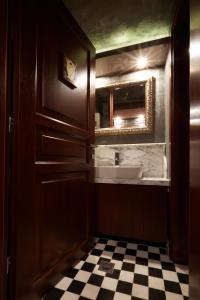 a bathroom with a sink and a mirror and a door at Veritas Boutique Art Hotel in Veria