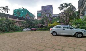 a white car parked in a parking lot at Itsy By Treebo - Hill Town 500 Mtrs From Madikeri Fort in Madikeri