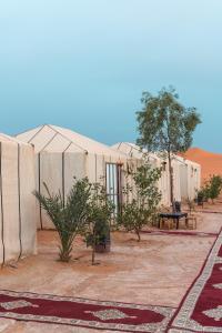 a row of tents in the middle of a desert at Overnight Camp Erg Chebbi in Merzouga